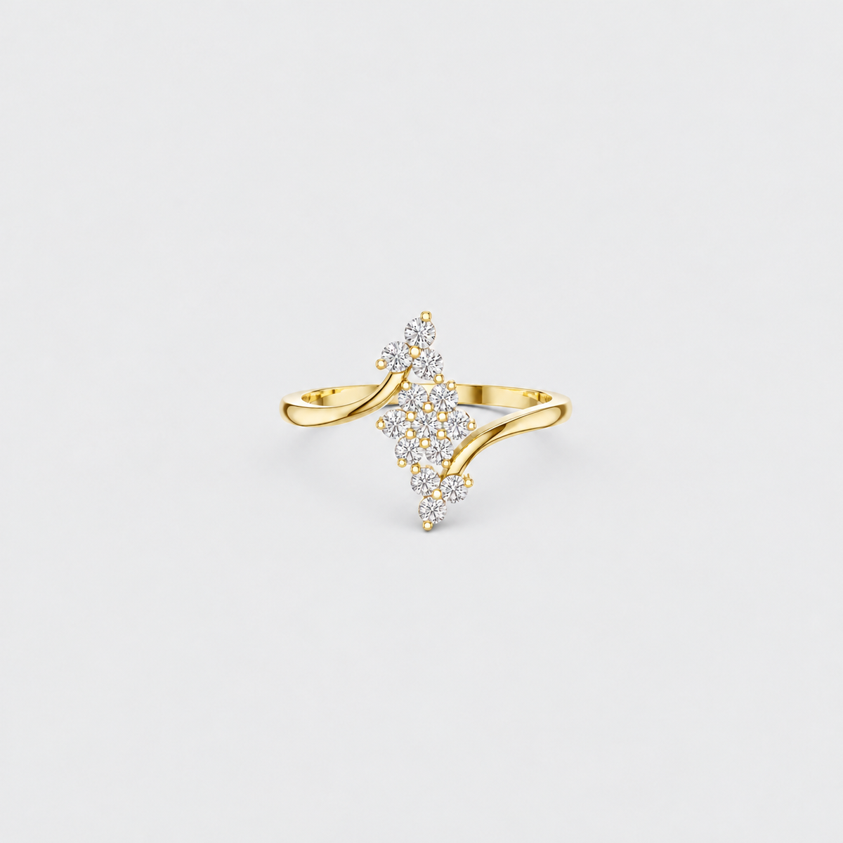A gold ring featuring a central diamond-shaped cluster of small clear stones, set on a smooth curved gold band, photographed against a light gray background.