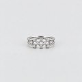 A silver ring featuring a decorative cluster of small clear gemstones in a floral or starburst pattern, photographed on a clean light gray background.
