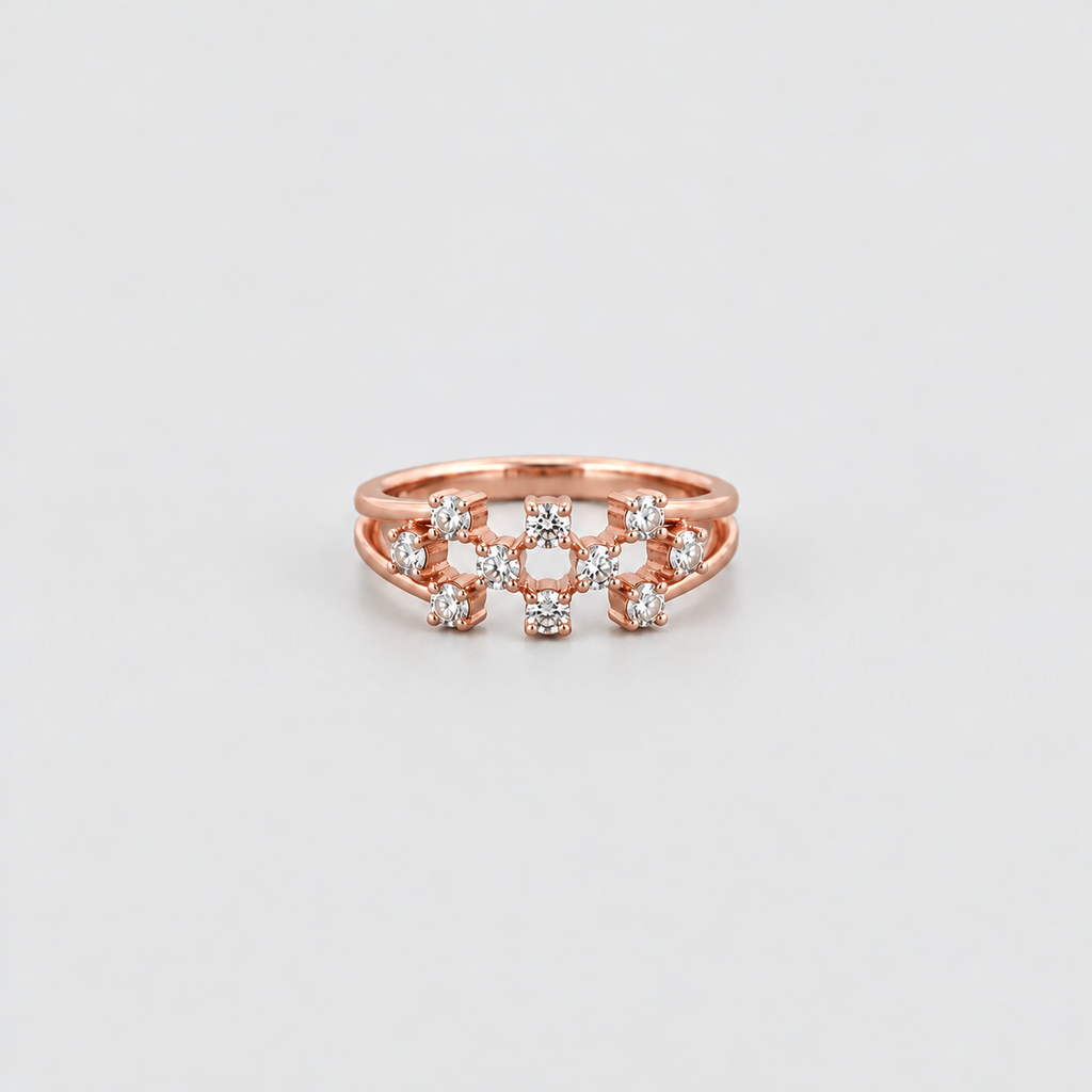 A rose gold ring with a multi-band design featuring small clear gemstones, photographed on a clean light gray background.