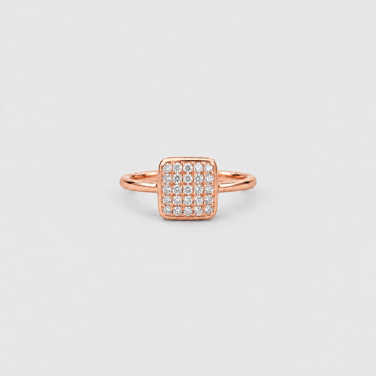 A rose gold ring with a square pavé diamond setting, photographed on a clean, light gray background.