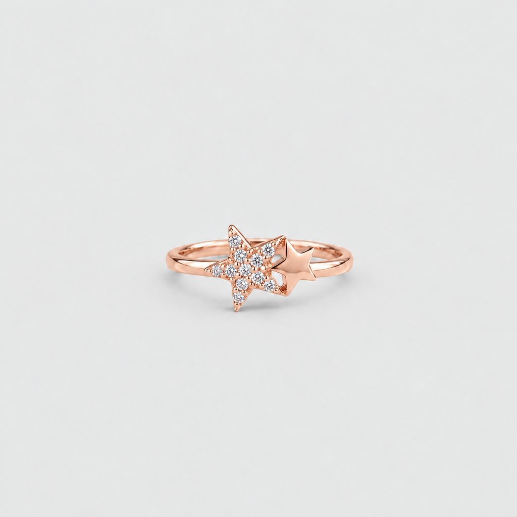 A rose gold ring featuring a star-shaped pavé diamond setting with a small star accent on the band, shown against a light gray background.