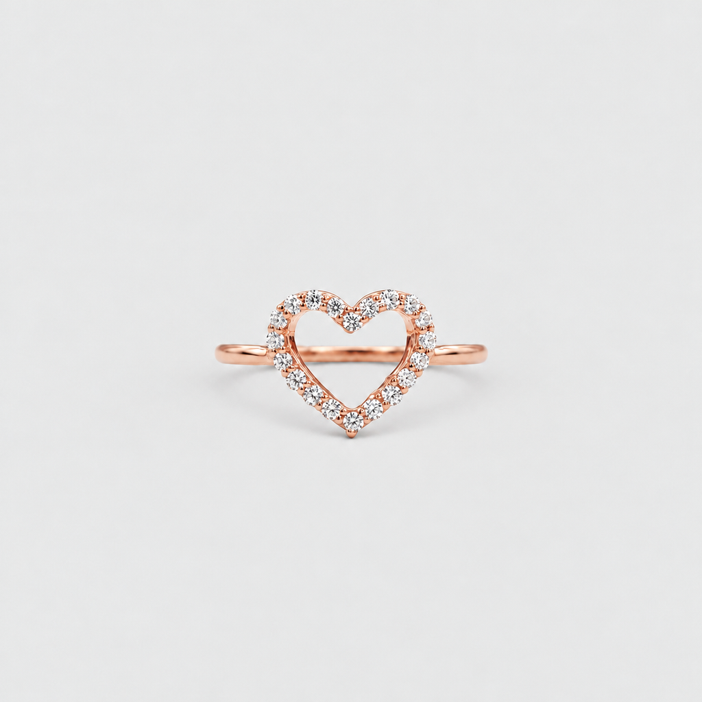 A rose gold open heart ring with a delicate border of small clear stones, centered on a light gray background.