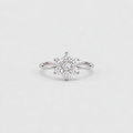 A silver-toned ring featuring a flower-shaped cluster of small clear gemstones on a plain light gray background.