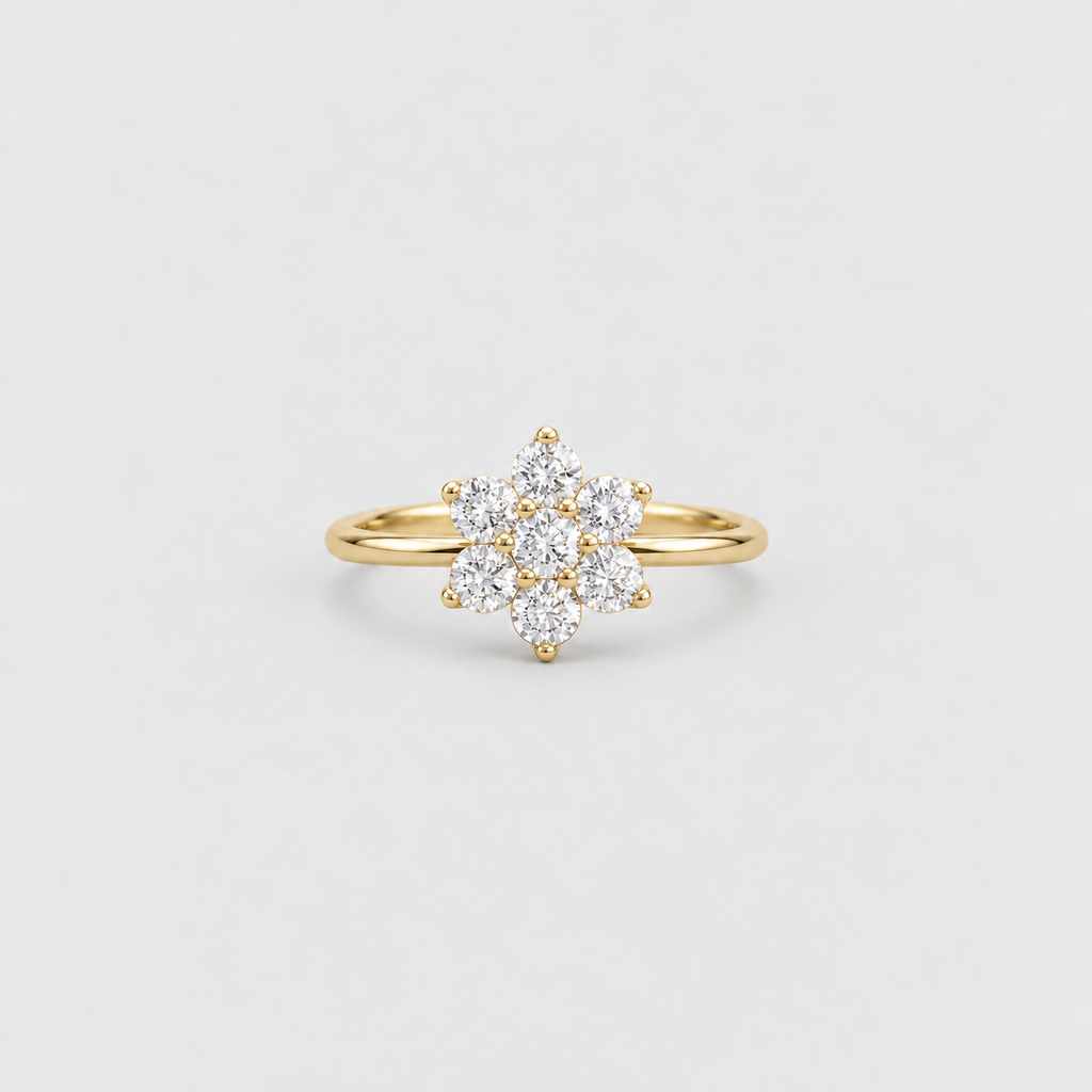 A yellow gold ring featuring a cluster of clear round-cut gemstones arranged in a floral or snowflake-like pattern, set on a slender gold band against a light gray background.
