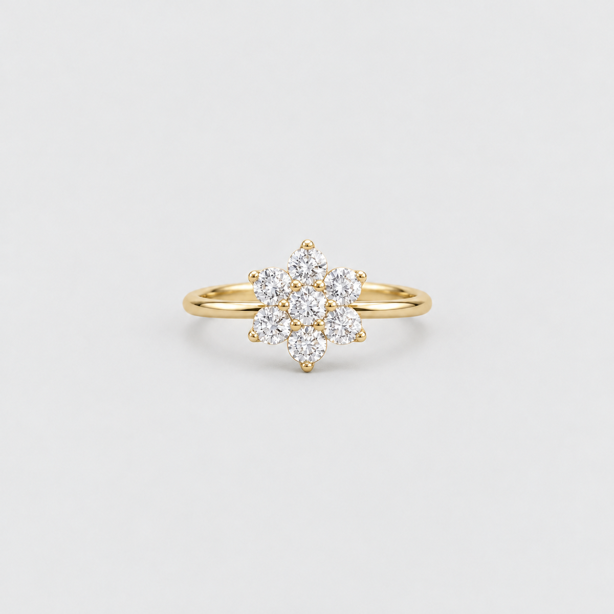 A yellow gold ring featuring a cluster of clear round-cut gemstones arranged in a floral or snowflake-like pattern, set on a slender gold band against a light gray background.