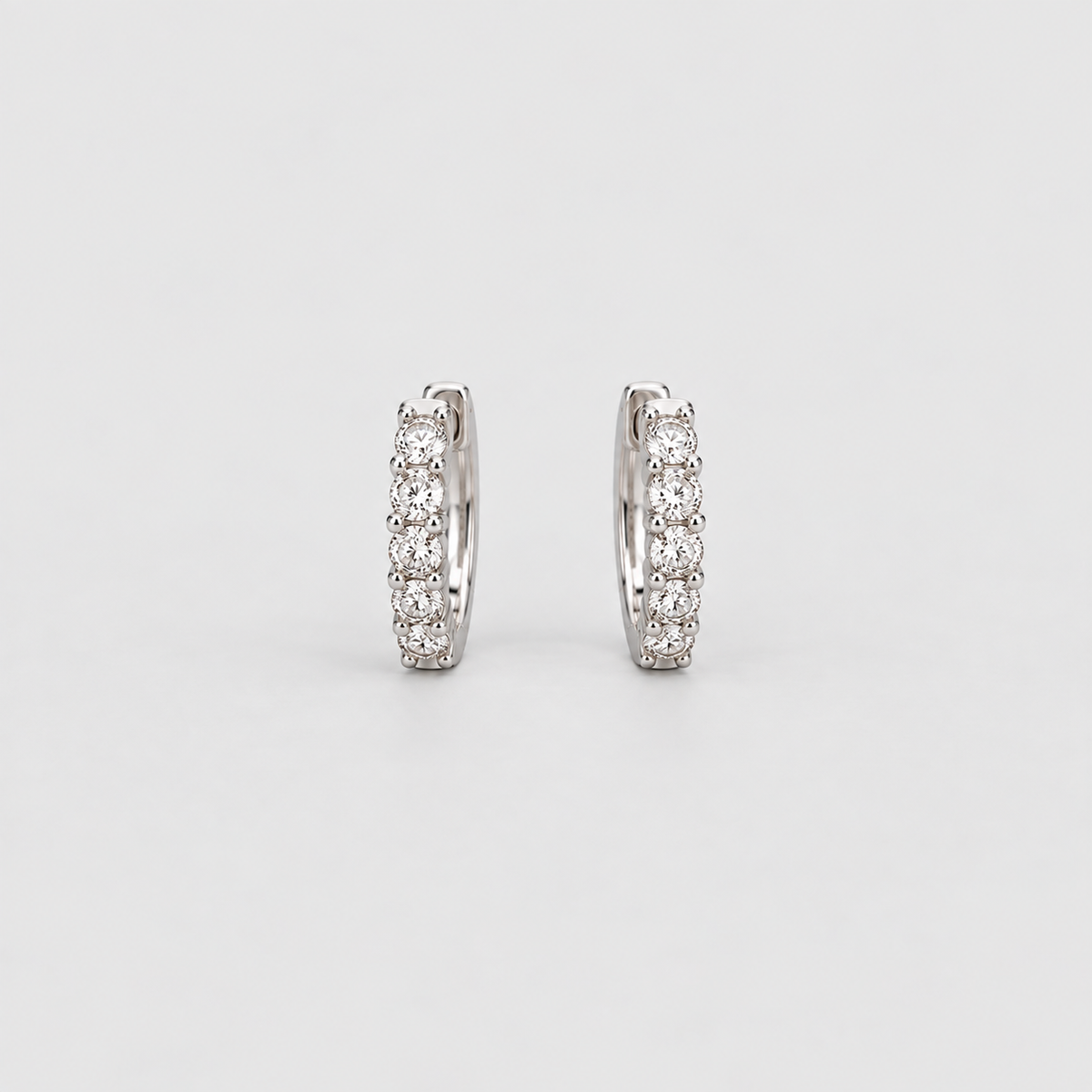 Lab grown diamond huggie hoop earrings in white gold with five round cut diamonds each, front view