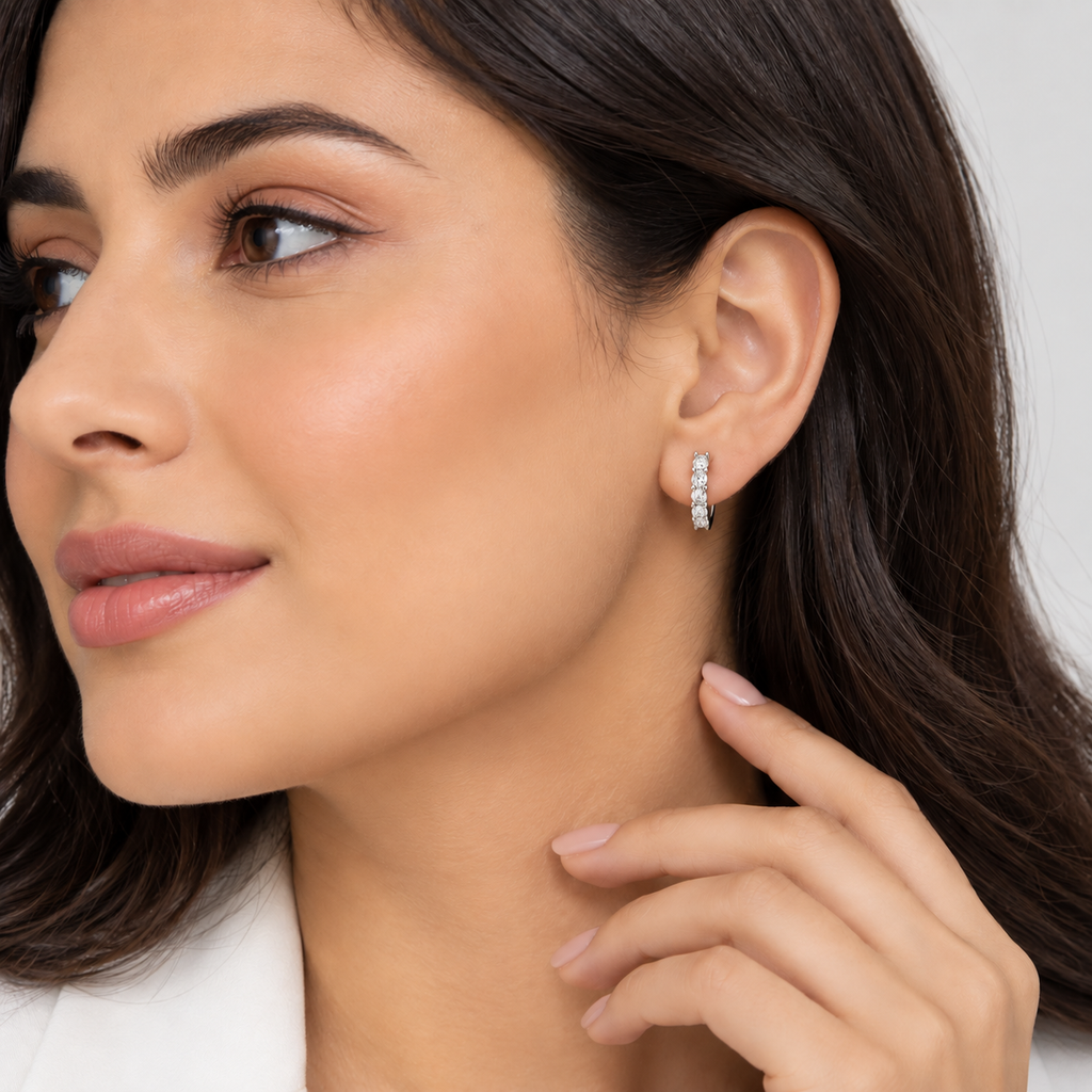 Woman wearing lab grown diamond huggie hoop earrings with round cut diamonds in white gold, side profile