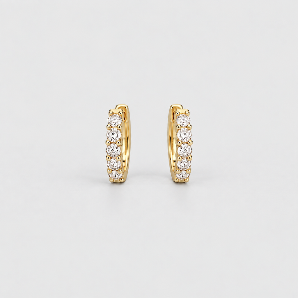 Classic yellow gold huggie hoop earrings with a row of sparkling round lab grown diamonds on a light gray background