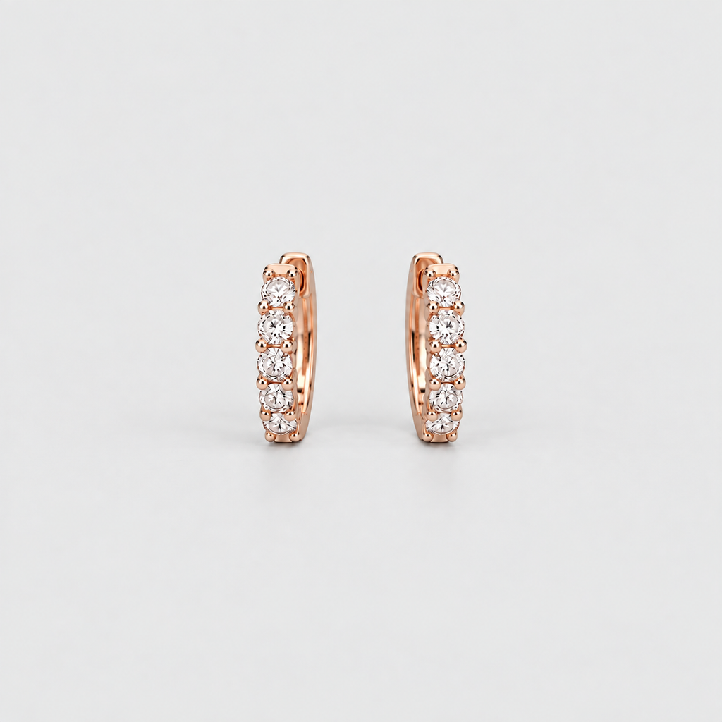 Elegant rose gold huggie hoop earrings with a row of sparkling round lab grown diamonds on a light gray background