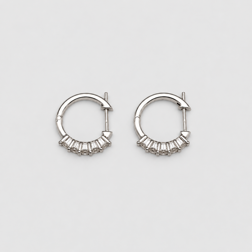 Sparkling white gold hoop earrings with a row of baguette lab grown diamonds on a light gray background