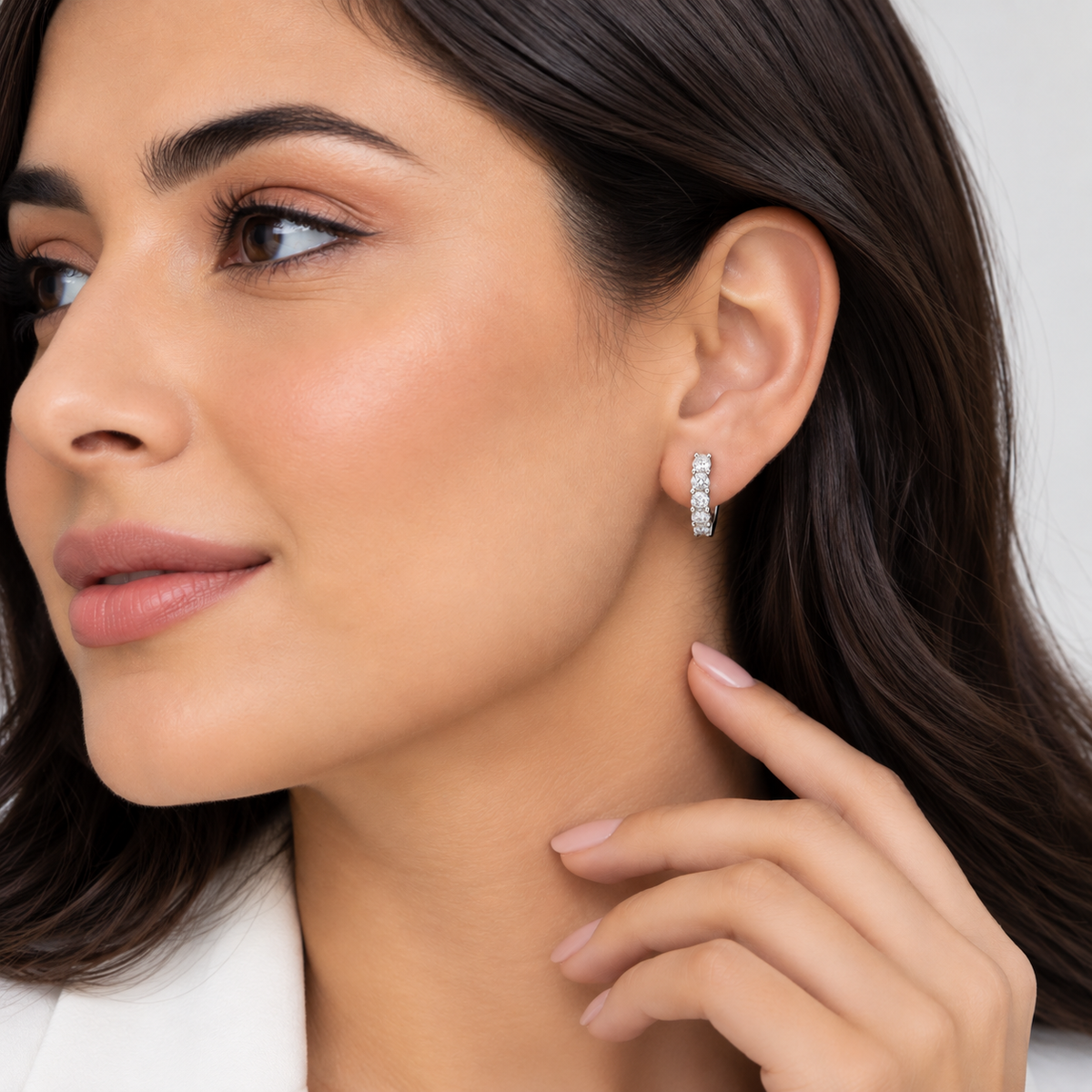 Model showcasing round cut lab grown diamond huggie hoops in white gold, elegant everyday jewelry look