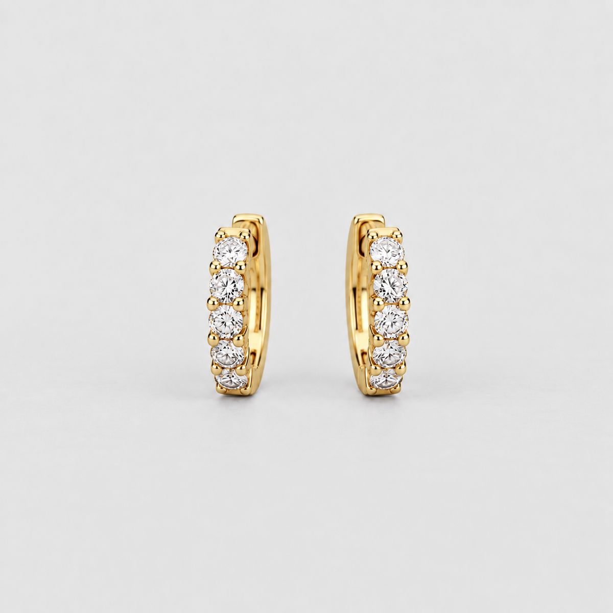Classic yellow gold huggie earrings with a graduated row of sparkling round cut lab grown diamonds