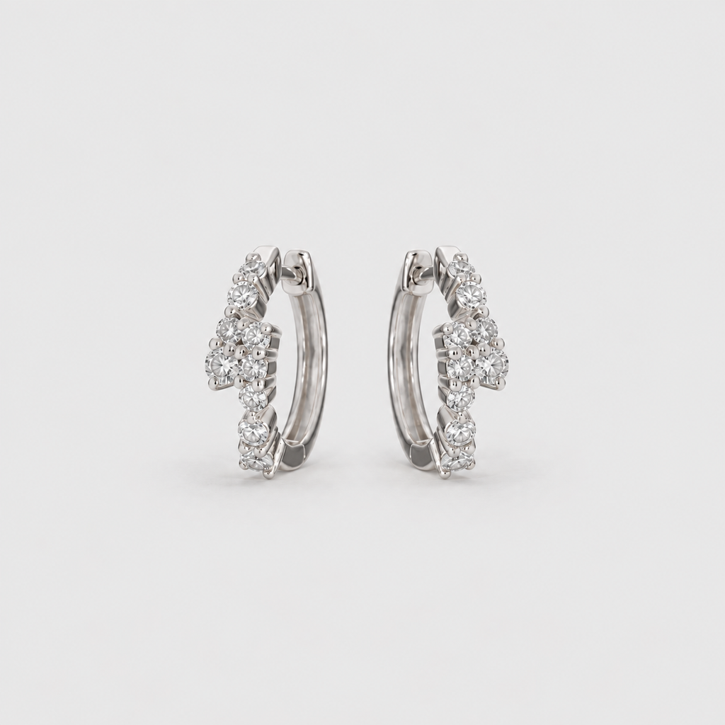Lab grown diamond cluster huggie hoop earrings in white gold with scattered round cut diamonds, angled view