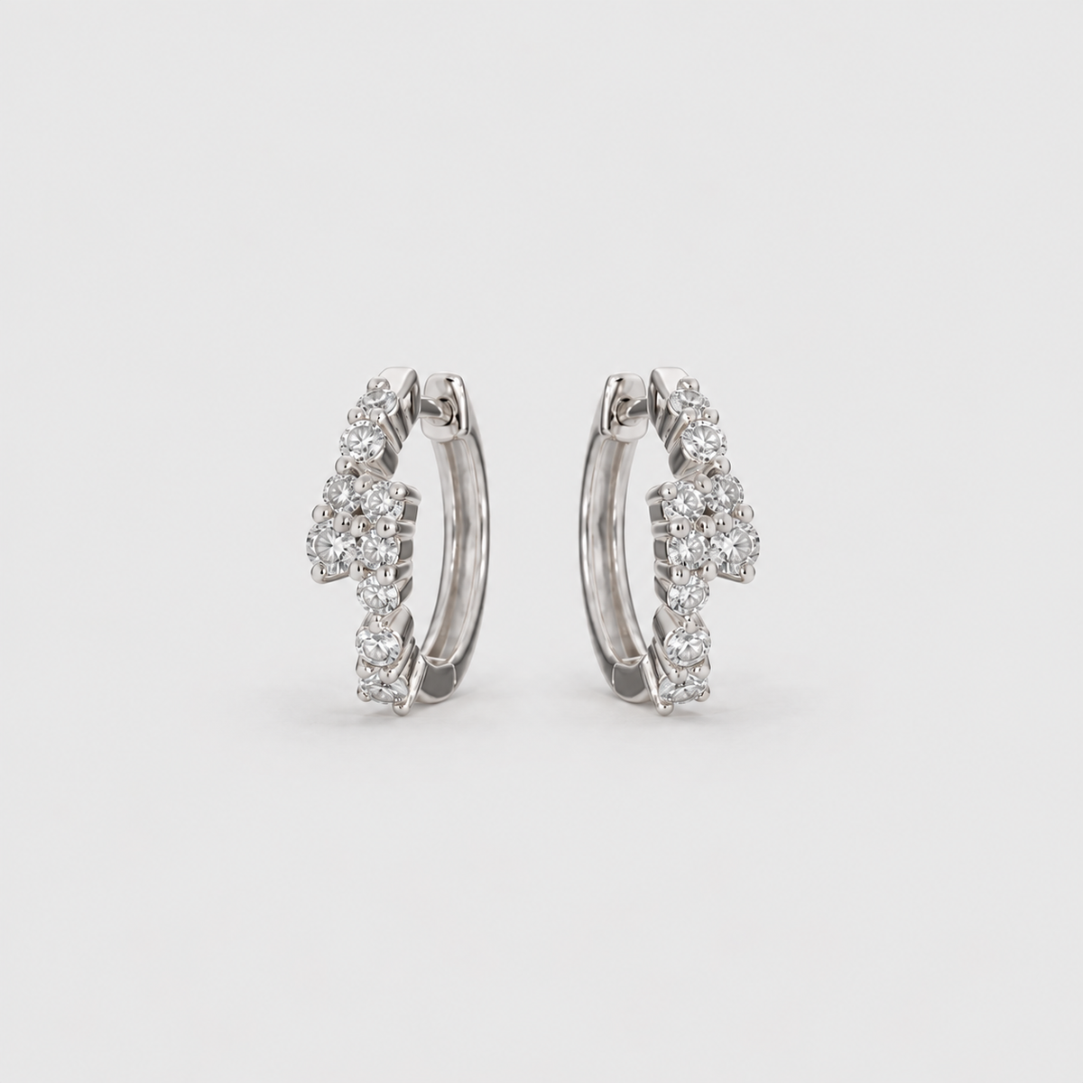 Lab grown diamond cluster huggie hoop earrings in white gold with scattered round cut diamonds, angled view