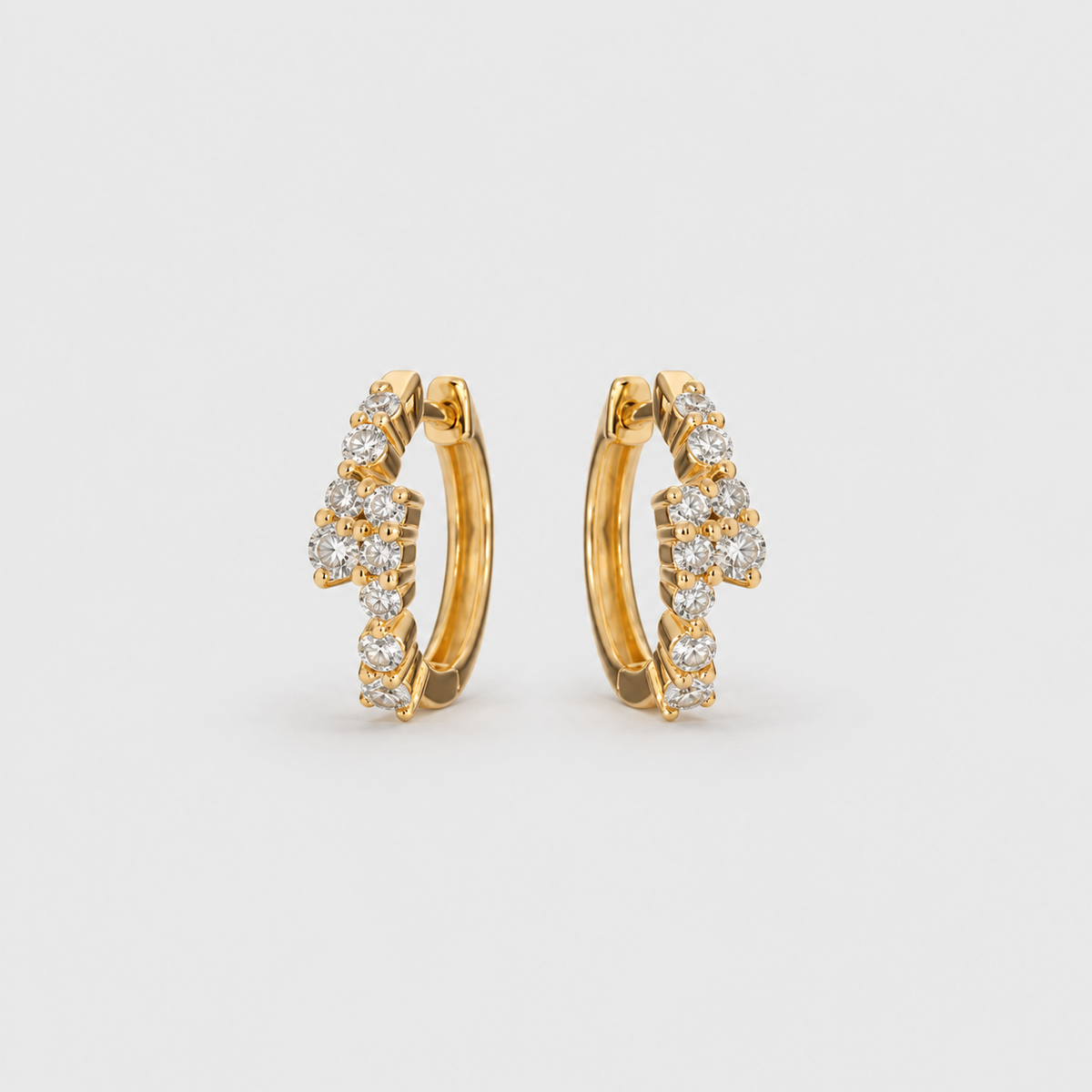 Lab grown diamond cluster huggie hoop earrings in yellow gold with scattered round cut diamonds, angled view