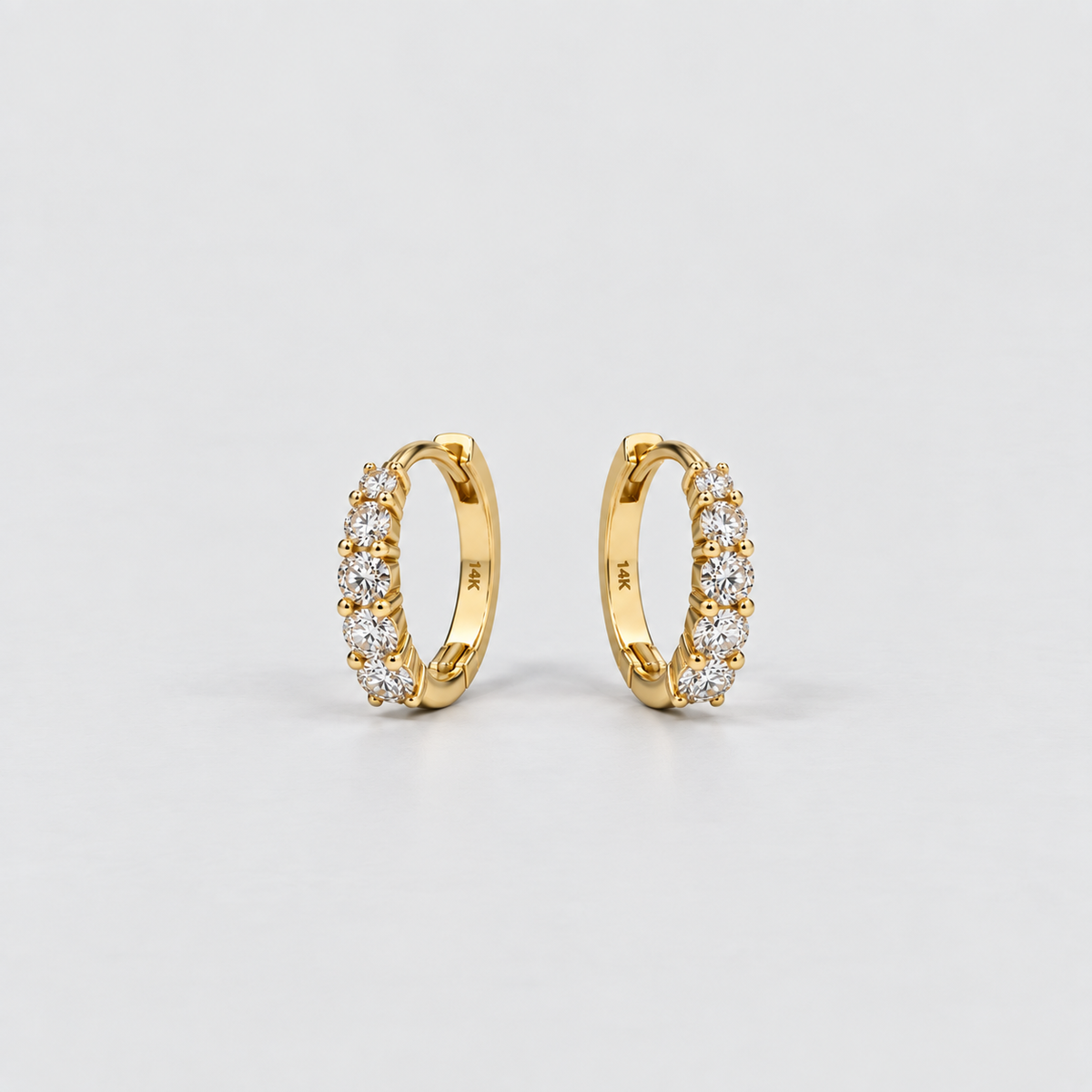 Lab grown diamond huggie earrings in 14K yellow gold, prong setting, shown as a pair on a neutral background