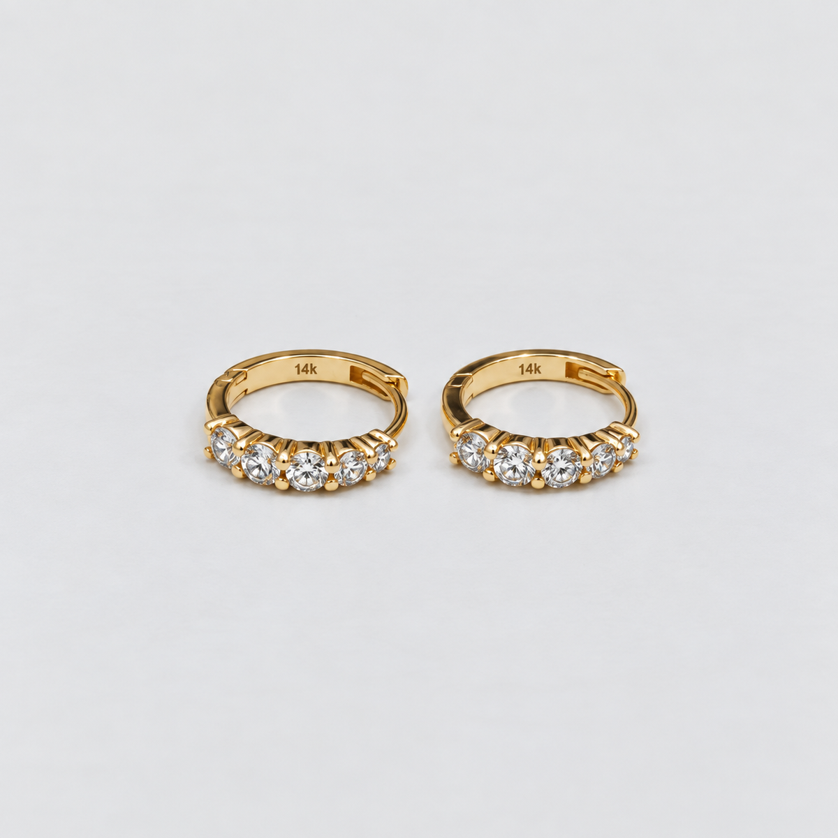 14K yellow gold lab grown diamond huggie hoop earrings with five round cut diamonds each, top-down view