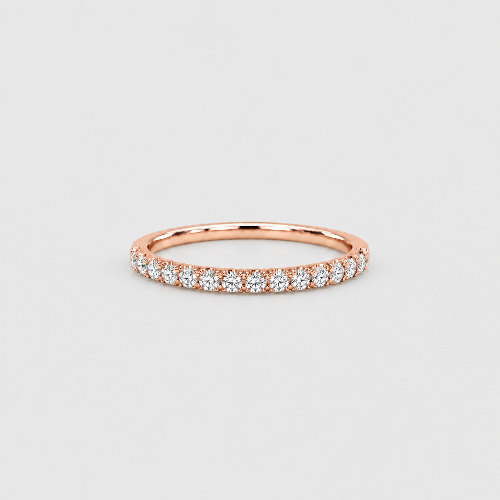 A rose gold eternity ring set with round brilliant-cut diamonds, shown on a light gray background.