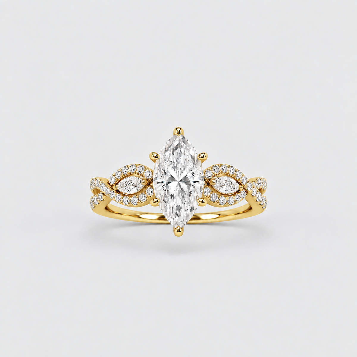 A yellow gold marquise-cut diamond ring with a halo of small diamonds on the band and matching diamond accents on the shoulders, centered on a light gray background.