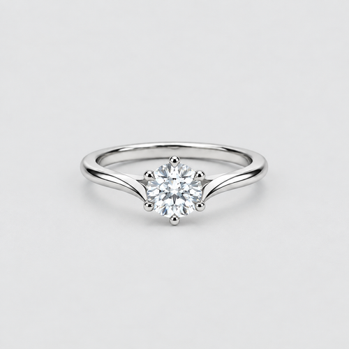A silver solitaire engagement ring with a round brilliant-cut diamond center stone, set on a plain light gray background.