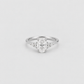 An oval-cut diamond engagement ring with a silver-colored band and small accent diamonds on either side, centered on a light gray background.