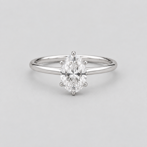 An oval-cut diamond engagement ring with a polished silver-colored band, photographed on a clean, light gray background.