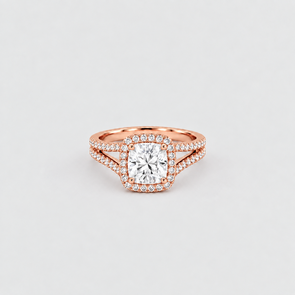 A rose gold engagement ring featuring a cushion-cut center diamond surrounded by a double halo of small pavé diamonds, with a split shank also accented by diamonds, set against a clean light gray background.
