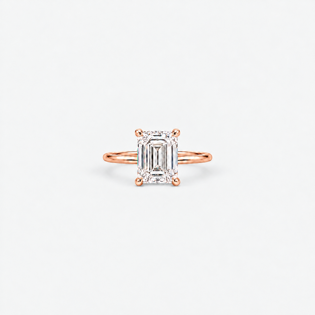 A rose gold engagement ring featuring an emerald-cut diamond center stone in a four-prong setting, shown on a clean white background.