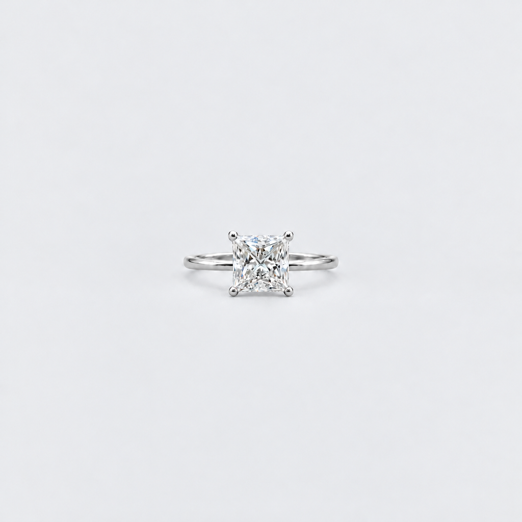 A classic solitaire engagement ring featuring a brilliant round-cut diamond set in a silver-colored metal band, centered on a clean white background.