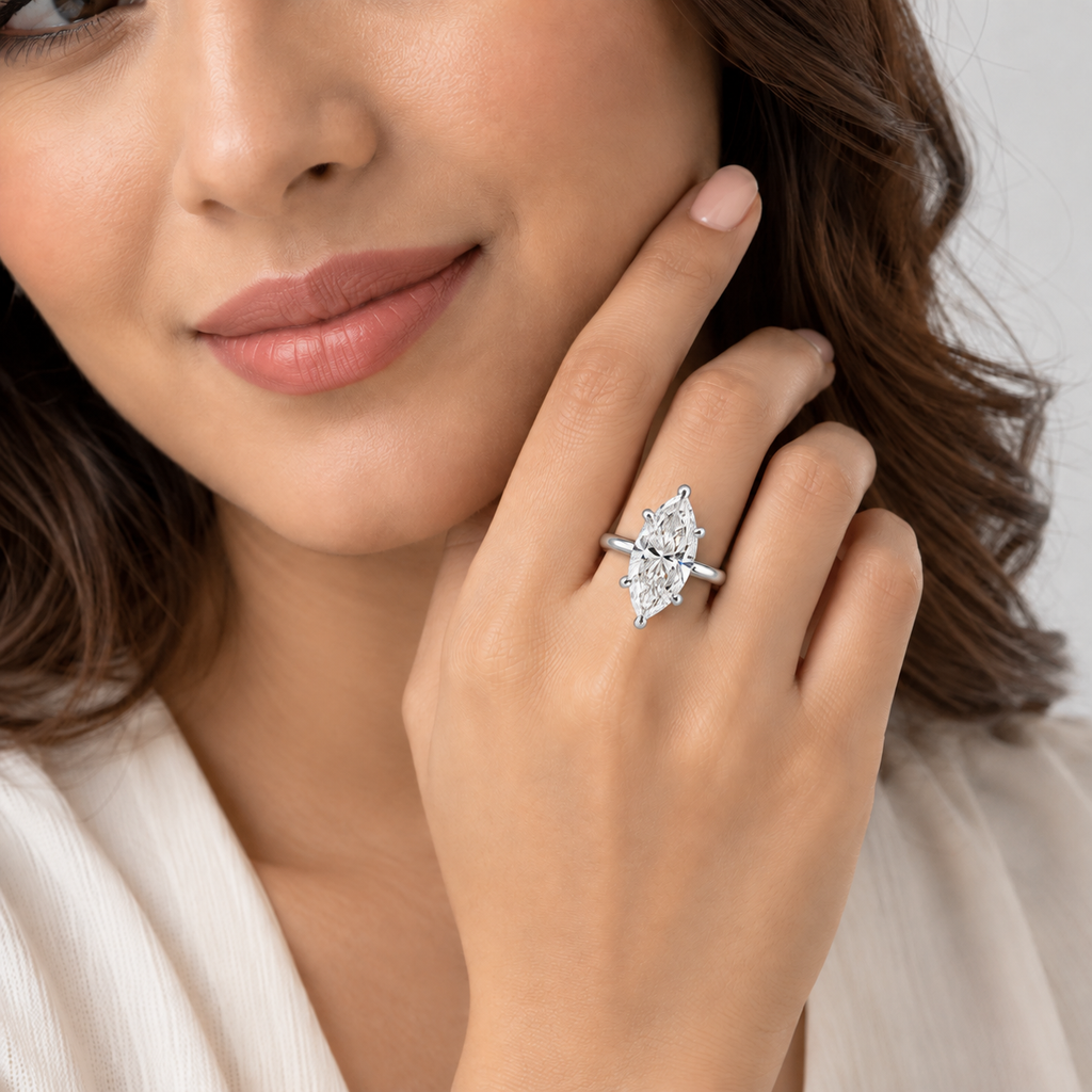A close-up lifestyle shot of a woman wearing a silver ring with a marquise-cut clear gemstone on her finger.
