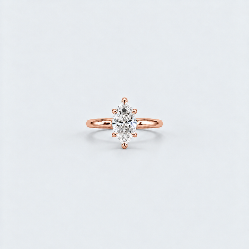 A rose gold ring with a marquise-cut diamond set in a six-prong setting, centered on a light gray background.