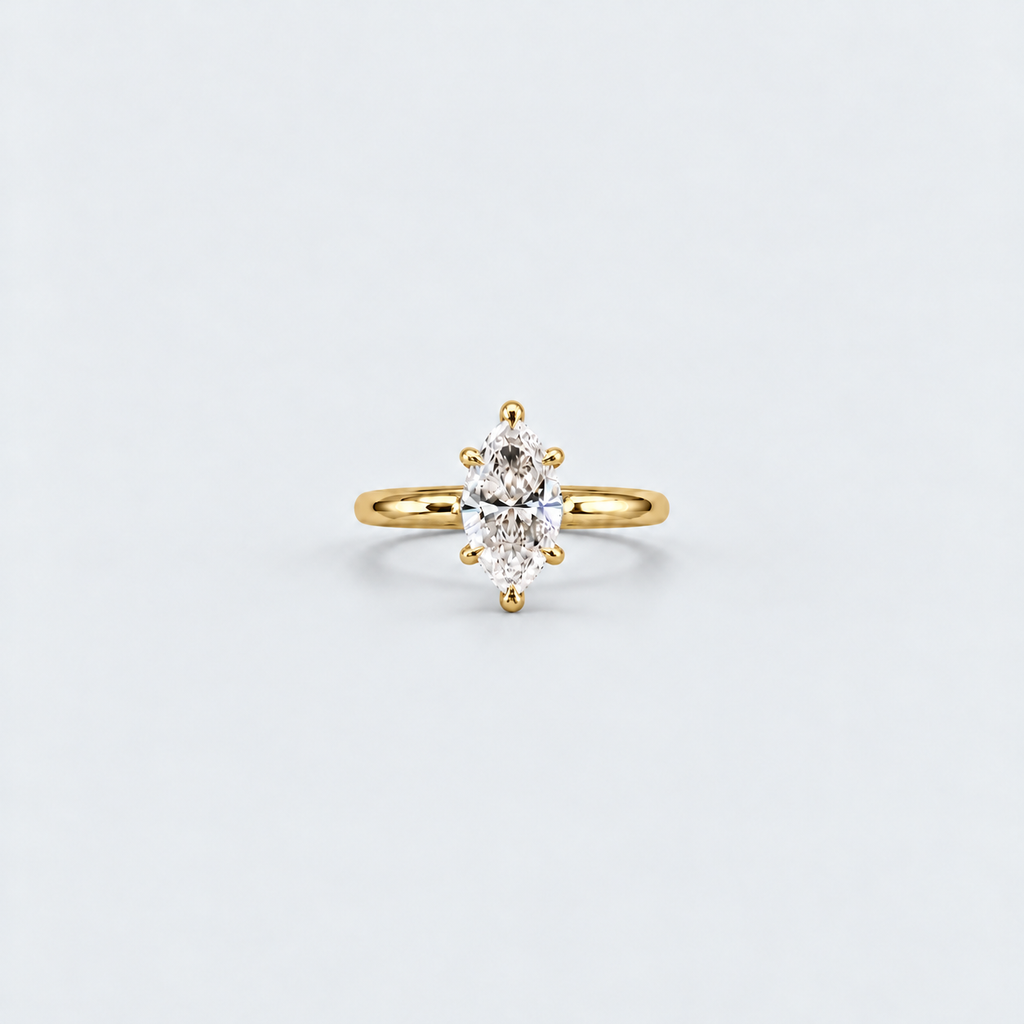 A yellow gold ring featuring an oval-cut clear gemstone in a prong setting, centered on a light gray background.