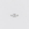 An engagement ring featuring a radiant-cut diamond set in a polished white gold or platinum band, centered on a light gray background.