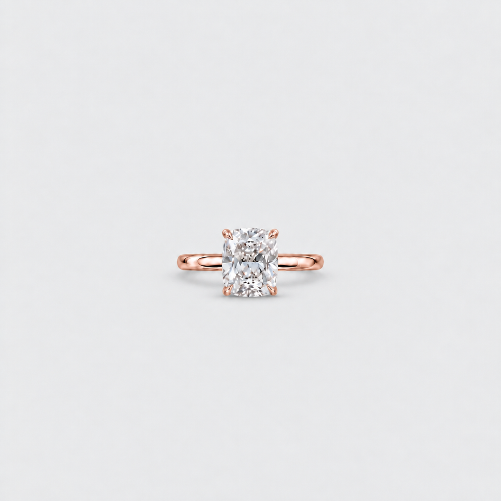 A single solitaire engagement ring featuring a radiant-cut diamond set in a rose gold band, centered on a light gray background.