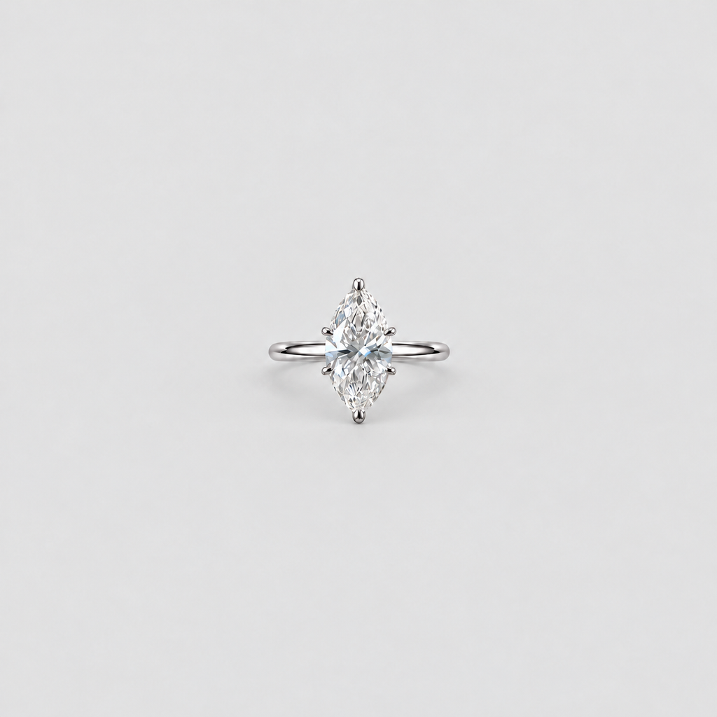 A single marquise-cut diamond engagement ring in a silver-toned setting, centered on a light gray background.