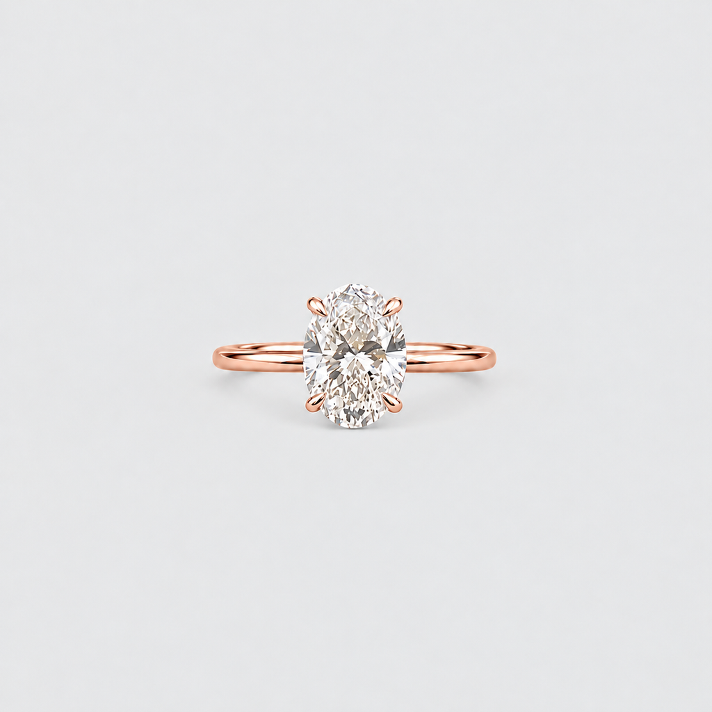 A rose gold engagement ring featuring a large oval-cut diamond set in a four-prong setting, centered on a light gray background.