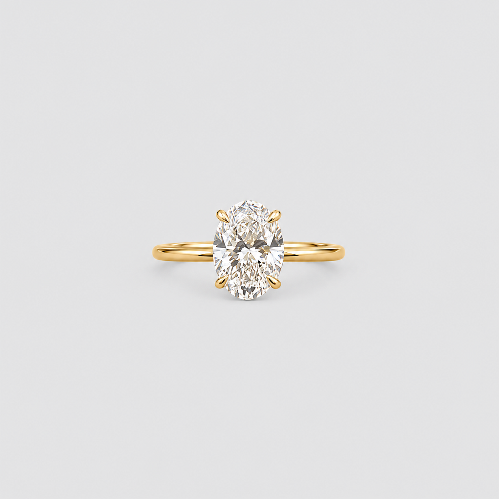 A yellow gold solitaire ring featuring an oval-cut diamond in a four-prong setting, centered on a light gray background.