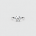 A classic solitaire engagement ring featuring a round brilliant-cut diamond set in a polished silver-colored metal band, centered on a light gray background.