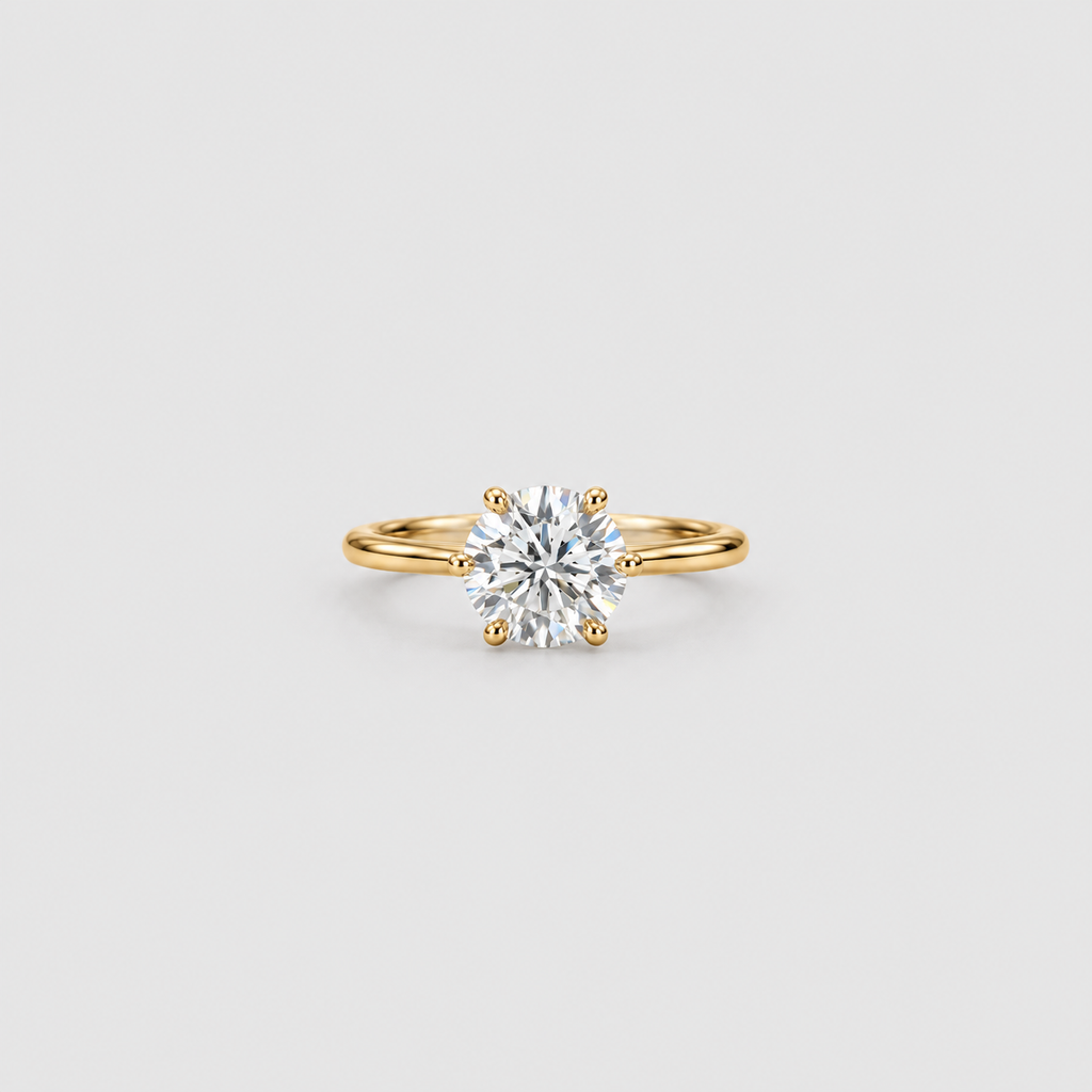 A classic solitaire engagement ring featuring a round brilliant-cut diamond set in a yellow gold band with a four-prong setting, centered on a light gray background.