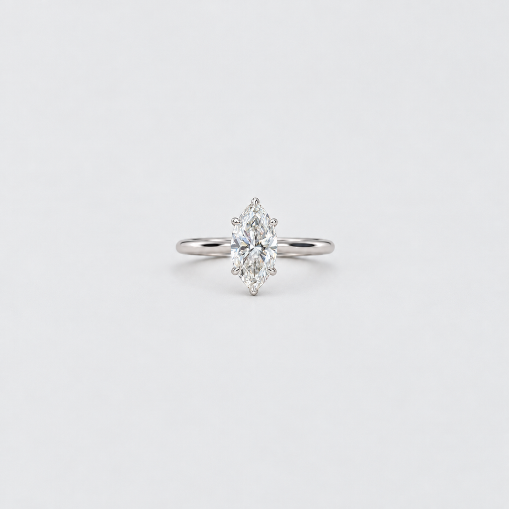A silver ring featuring a marquise-cut diamond cluster setting on a plain light gray background.