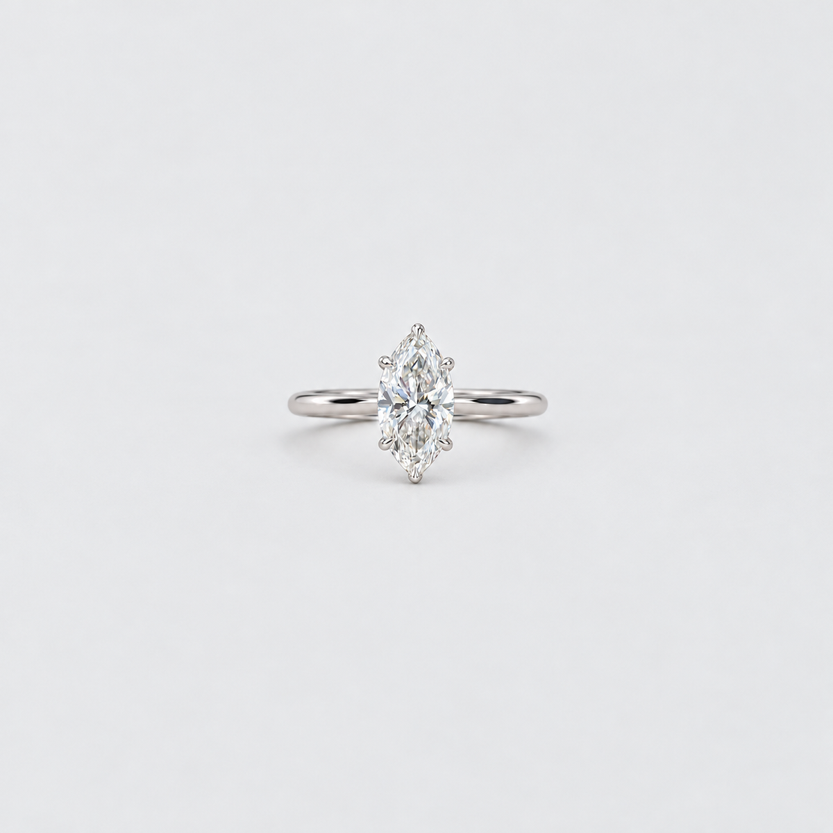 A silver ring featuring a marquise-cut diamond cluster setting on a plain light gray background.