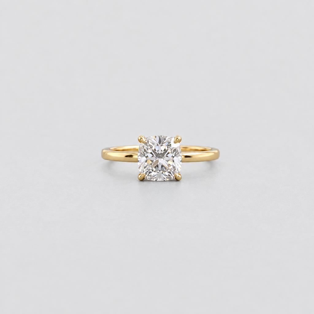 A classic yellow gold solitaire ring featuring a brilliant round-cut diamond, set against a clean light gray background.