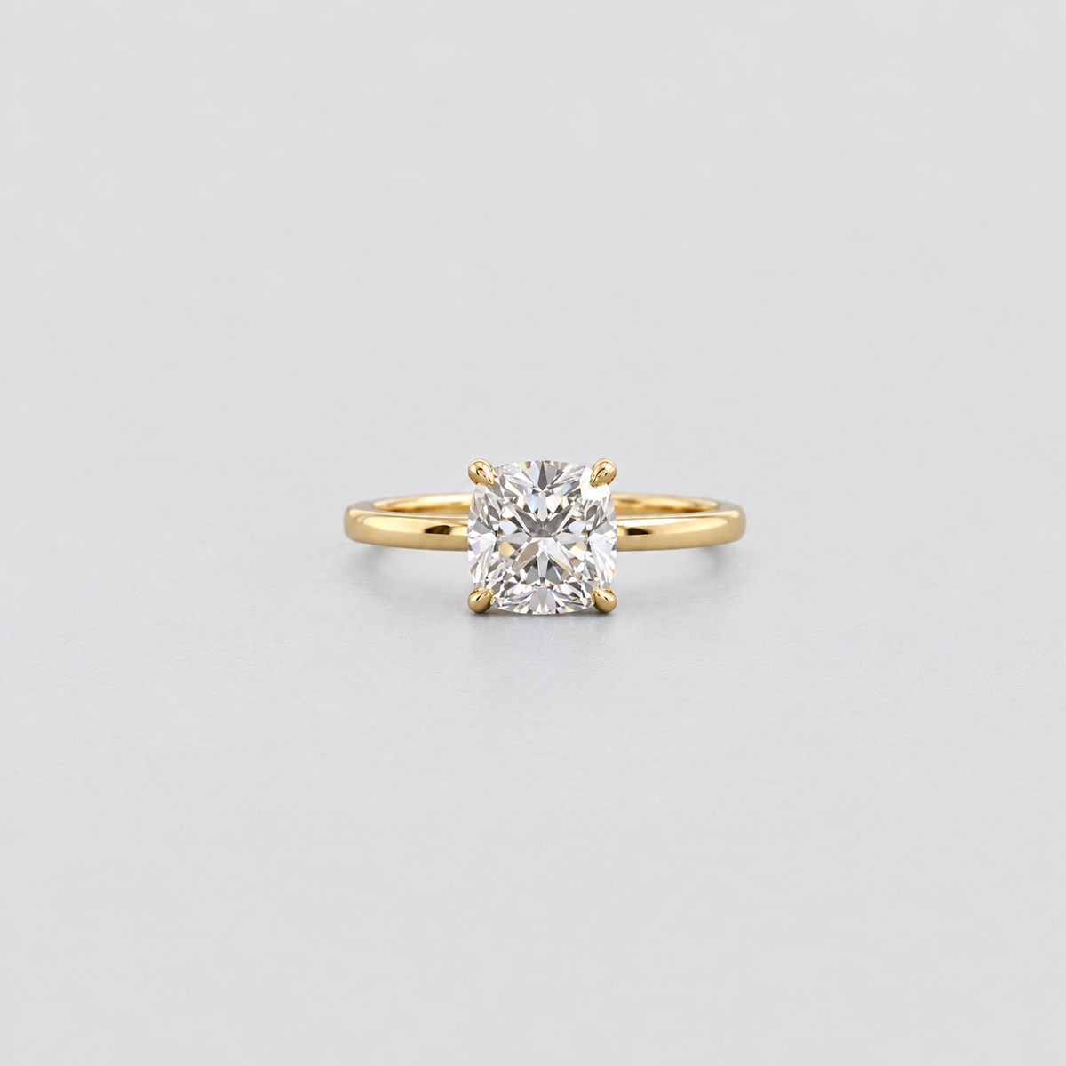 A classic yellow gold solitaire ring featuring a brilliant round-cut diamond, set against a clean light gray background.
