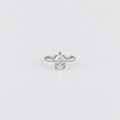 A silver ring featuring a pear-cut diamond cluster setting, centered on a plain light gray background.