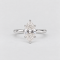 A silver engagement ring featuring a marquise-cut diamond center stone in a six-prong setting, shown on a light gray background.