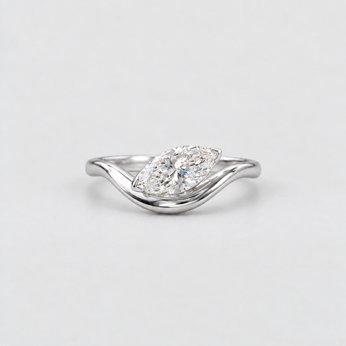 A silver wave ring with a marquise-cut diamond center stone, photographed on a clean, light gray background.