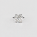 An emerald-cut diamond ring with a silver-toned band, centered on a clean, light gray background.