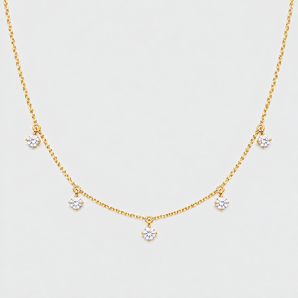 A delicate gold chain necklace featuring five small, clear flower-shaped crystal charms spaced along the chain, displayed against a light gray background.