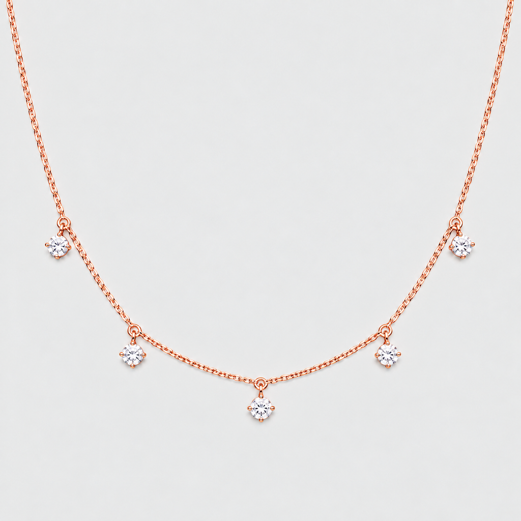 A delicate rose gold necklace with five small flower-shaped crystal charms spaced along a fine chain, displayed against a light gray background.