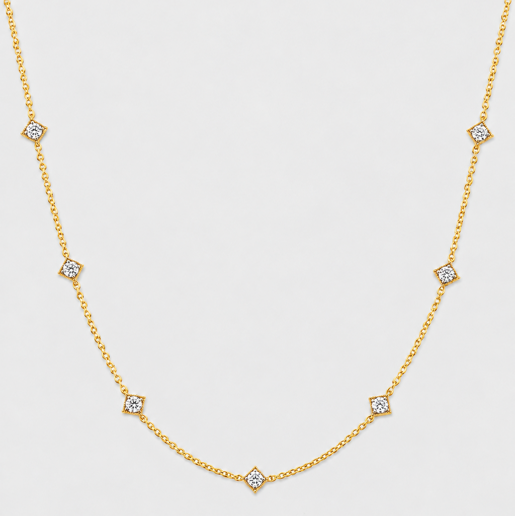 A delicate gold chain necklace featuring seven small diamond-shaped settings with clear stones, arranged in a gentle curve on a light gray background.